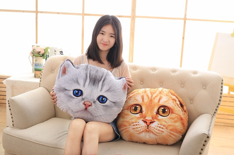 Woman holding two cat-shaped cushions with a neutral background