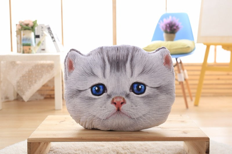 Cat-shaped pillow on a wooden table with a blurred indoor background