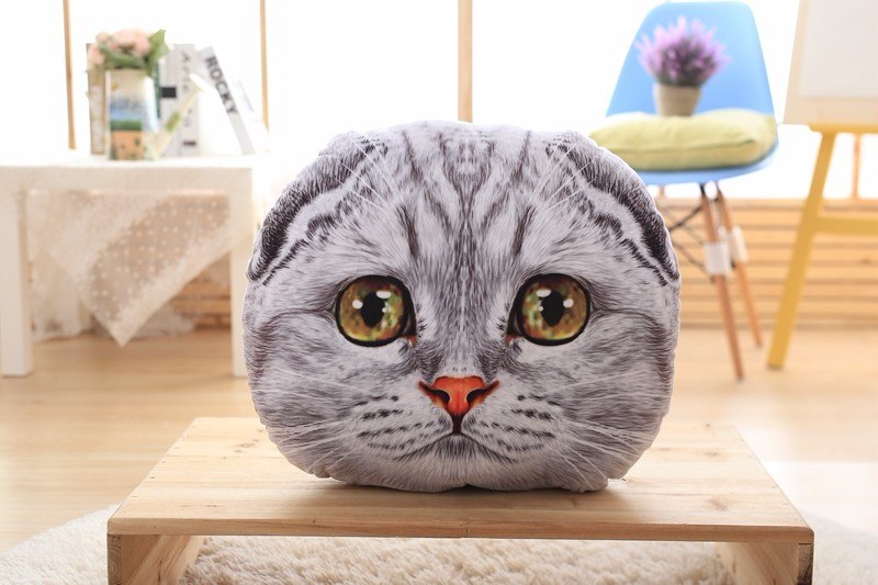 Cat-shaped pillow on a wooden table with a blurred indoor background
