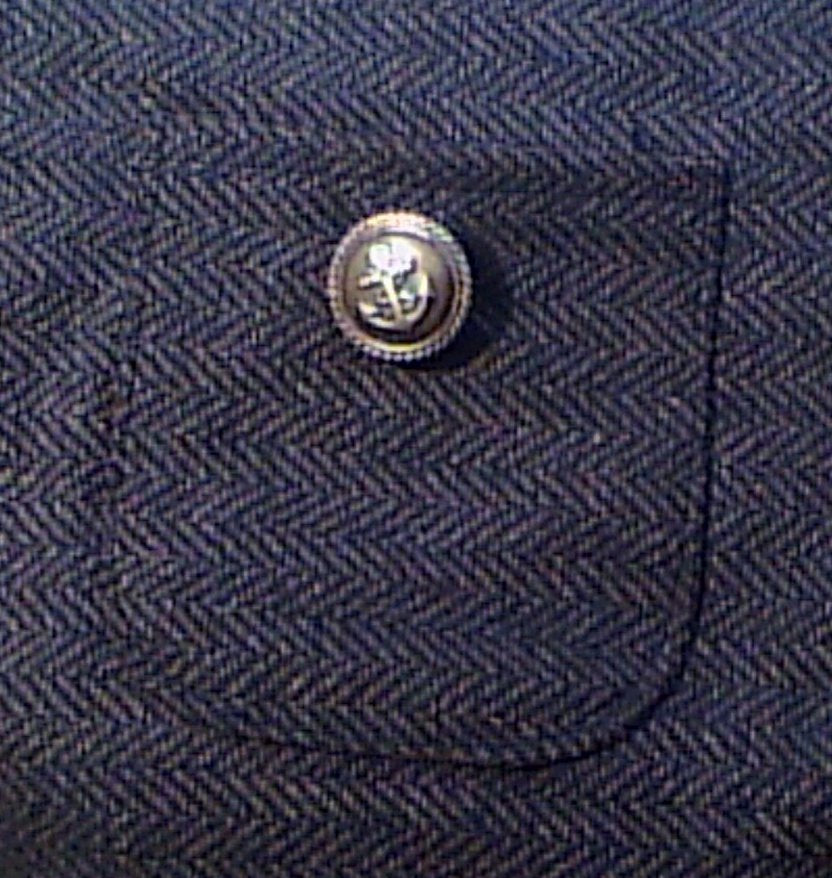 Close-up of a button on a textured blue fabric